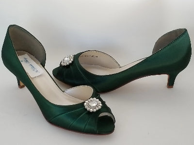A pair of hunter green satin kitten heel shoes with a peep toe with a small crystal design on the front of the shoes