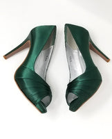A pair of high heeled hunter green satin shoes with a peep toe and a hidden platform at the front of the shoes 
