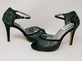 A pair of hunter green lace high heeled shoes with a front hidden platform and an ankle strap with a peep toe