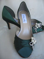A pair of hunter green satin medium height heel bridal shoes with a peep toe and designed with a crystal design on the front of the shoes and a crystal design on the back heel of the shoes