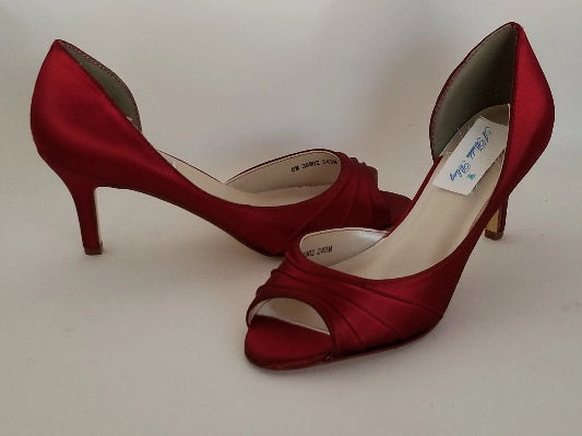 A pair of red satin medium height heel shoes with a peep toe