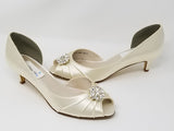 A pair of  ivory satin kitten heels with a peep toe and designed with a crystal design on the front of the shoes