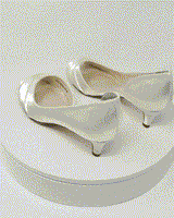 A pair of ivory low heel satin kitten heel shoes with a peep toe