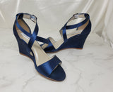 A pair of navy blue wedding shoes with high wedge and straps across the front of the foot 