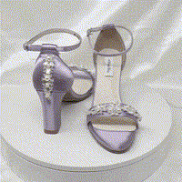 A pair of lilac purple block heel shoes with an ankle strap and a crystal and pearl design on the front toe strap of the shoes and a crystal and pearl design on the heel of the shoes