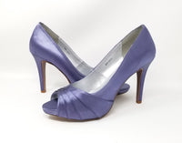 A pair of high heeled lilac purple satin shoes with a peep toe and a hidden platform at the front of the shoes 