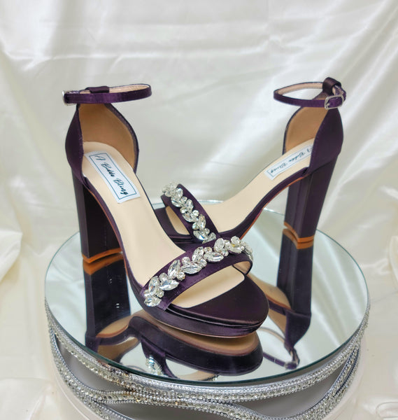 a pair of high heel block shoes dyed eggplant purple with a sparkling crystal design on the front toe strap