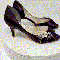 eggplant purple wedding shoes with peep toe and medium heel with a pearl and crystal bow design on the side of the shoes
