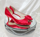 A pair of red satin kitten heel shoes with a peep toe