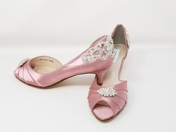A pair of dusty rose satin kitten heels with a peep toe and designed with a crystal design on the front of the shoes and a crystal design on the back heel of the shoes