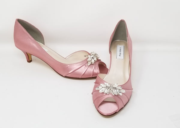 A pair of dusty rose satin kitten heels with a peep toe and designed with a crystal design on the front of the shoes