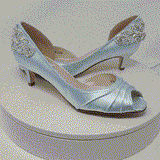 A pair of baby blue satin kitten heels with a peep toe and designed with a crystal design on the front of the shoes and a large crystal design on the back heel of the shoes